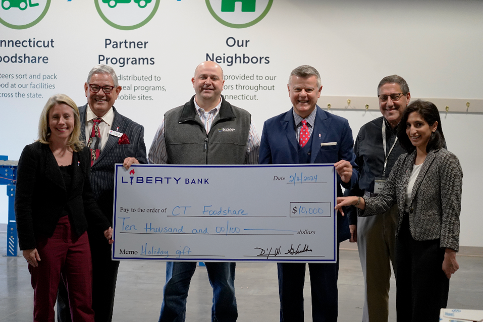 Six people holding a giant $10,000 check